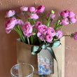 Load image into Gallery viewer, Bouquet of pink flowers with a glass vase on a wooden surface