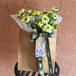Load image into Gallery viewer, Bouquet of flowers in a brown paper bag with Farmgate flowers Tasmanian grown on a textured brown background