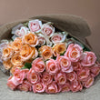 Load image into Gallery viewer, Bouquet of pink, orange, and white roses in a decorative hat on a neutral background
